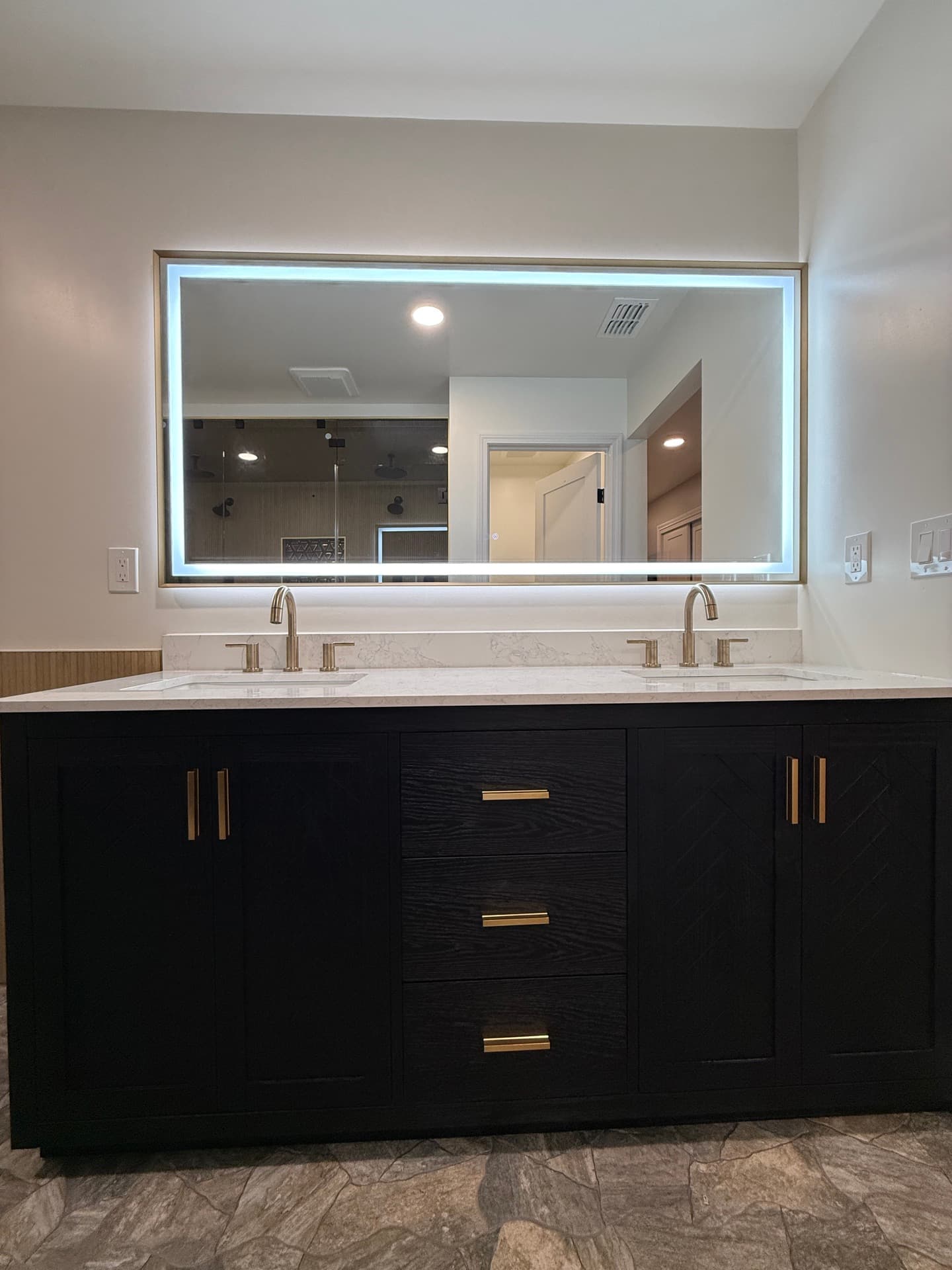 Backlit smart mirror above a wood-tone vanity in a Fair Oaks master bathroom remodel