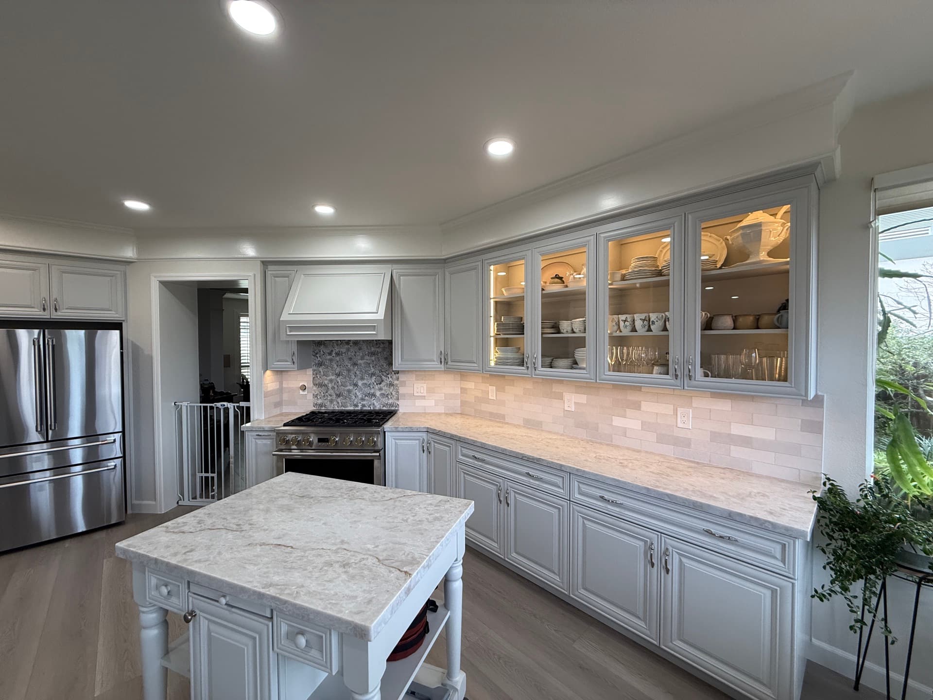 Granite Bay kitchen remodel with white floor-to-ceiling cabinetry, quartz peninsula and wide-plank wood floors