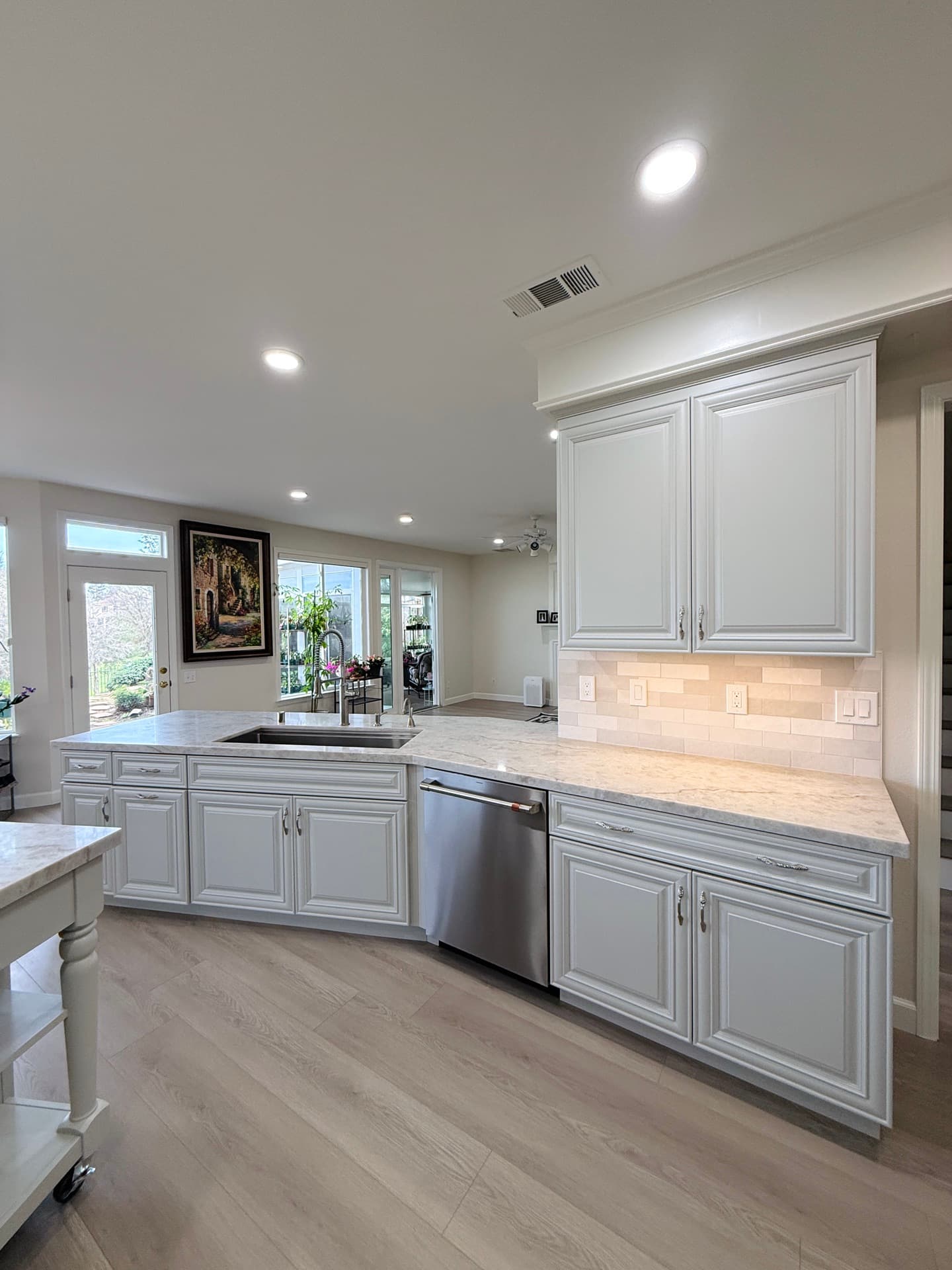 White Shaker kitchen cabinets with matte black hardware and quartz peninsula in a Granite Bay remodel