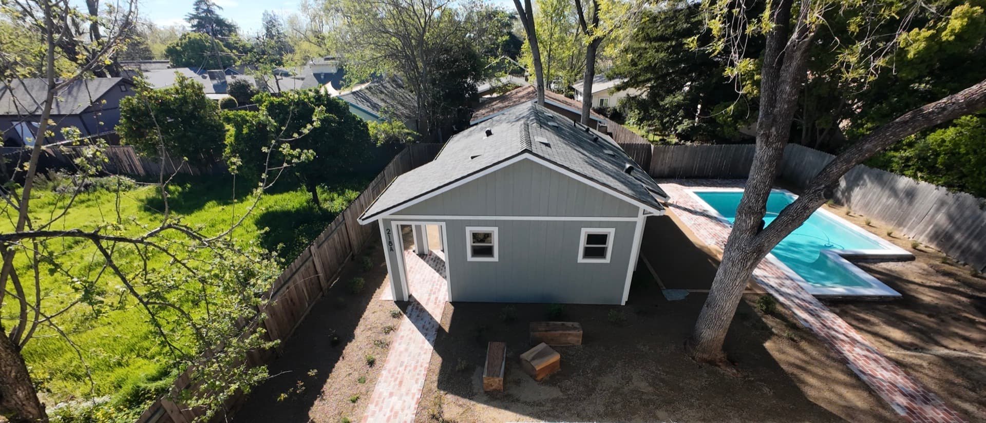 Aerial view of a newly built detached ADU in a Roseville backyard, beside the main residence